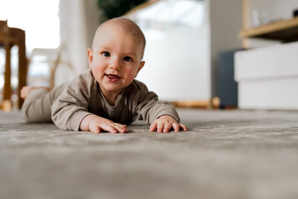 Kind liegt am Boden und wirkt entspannt und glücklich